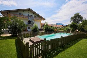 una valla alrededor de una piscina frente a una casa en Gasthof-Hotel Zur Post Samerberg, en Törwang