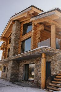 ein Haus aus Holz und Stein in der Unterkunft CABANA CEITREI - MOUNTAIN VIEW GIUMALAU in Cozăneşti