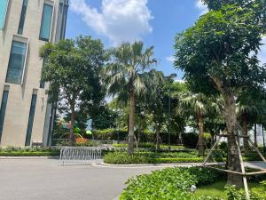 un parque con palmeras frente a un edificio en Vinhomes Skylake Apartments next to Keangnam,High floor City view with Balcony, en Hanói