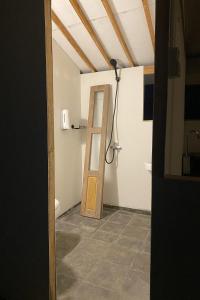 a bathroom with a wooden door in a room at Borobudur Luxury Glamping in Magelang