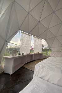 a white tent with a bed and some windows at Borobudur Luxury Glamping in Magelang