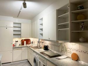 a kitchen with white cabinets and a dishwasher at Skyline View in Offenbach in Im Teller