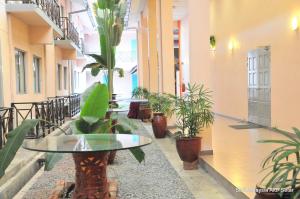 a room with potted plants and a table in a building at Hotel Seri Malaysia Alor Setar in Alor Setar