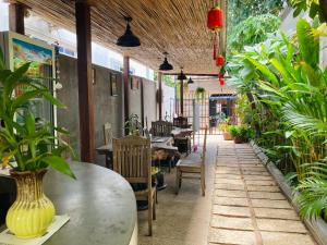 a restaurant with tables and chairs and potted plants at Lotus Haven Villa in Siem Reap