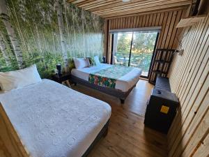 a room with two beds and a window in it at Lodge Los Bosques in Matanzas