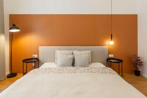 a bedroom with a large white bed with two tables at Luxurious Minimalist Residence with Sauna by Prestige Homes in Budapest