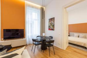 een woonkamer met een tafel en stoelen en een bed bij Luxurious Minimalist Residence with Sauna by Prestige Homes in Boedapest