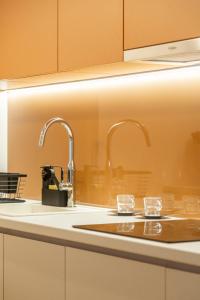 a kitchen with a sink with two glasses on it at Luxurious Minimalist Residence with Sauna by Prestige Homes in Budapest +24 photos
