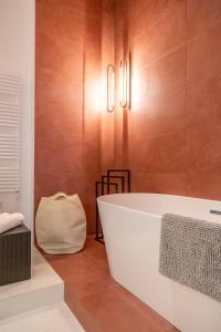 a bathroom with a white bath tub and wooden walls at Luxurious Minimalist Residence with Sauna by Prestige Homes in Budapest
