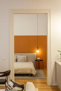 a bedroom with a bed with an orange wall at Luxurious Minimalist Residence with Sauna by Prestige Homes in Budapest