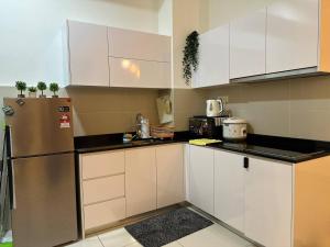 a kitchen with white cabinets and a stainless steel refrigerator at Educity Legoland Eco Botanic Homestay in Johor Bahru