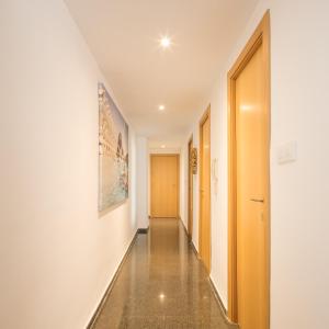 a hallway with white walls and a long hallway with wooden doors at Macflats Ciudad de las Ciencias in Valencia