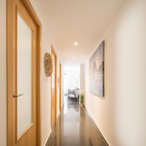 a hallway with white walls and an open door at Macflats Ciudad de las Ciencias in Valencia