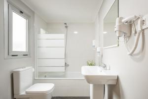 a white bathroom with a toilet and a sink at Macflats Ciudad de las Ciencias in Valencia