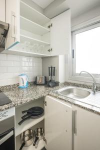 a white kitchen with a stove and a sink at Macflats Ciudad de las Ciencias in Valencia