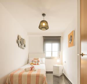 Habitación pequeña con cama y lámpara colgante en Macflats Ciudad de las Ciencias, en Valencia