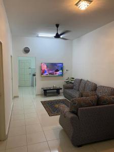 uma sala de estar com 2 sofás e uma televisão de ecrã plano em Anak Air Homestay, Serkam Islam Guest Only em Malaca