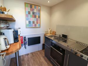 a kitchen with a stove top oven next to a counter at Bay Tree Studio in Alnmouth