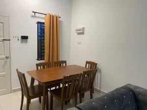 uma sala de jantar com uma mesa e cadeiras e um sofá em Anak Air Homestay, Serkam Islam Guest Only em Malaca
