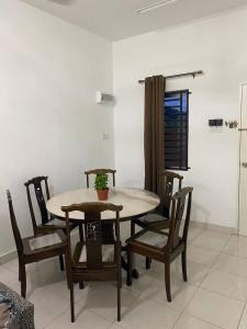 een eettafel en stoelen met een plant erop bij Anak Air Homestay, Serkam Islam Guest Only in Melaka