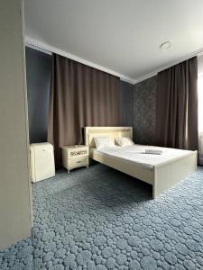 Un dormitorio con una cama grande y una ventana en Бутик-отель Мажор en Aktobé