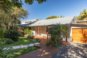 a home with a wooden deck and a garage at Lazuli in Blueys Beach