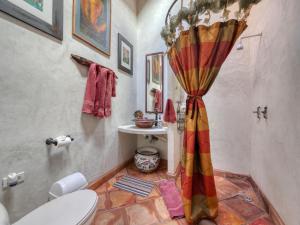 a bathroom with a shower curtain and a toilet at Quinta Maria en la Ruta del Vino in Valle de Guadalupe