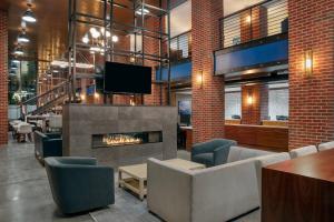 a lobby with a fireplace and chairs and a tv at Residence Inn by Marriott Norwalk in Norwalk