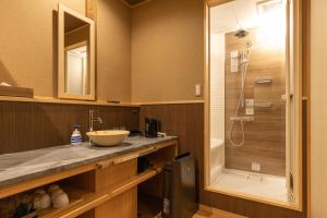 y baño con lavabo y ducha. en Classic ＆ modern SELF-STYLED HOTEL 番場おおそね en Chichibu