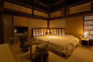 1 dormitorio con 1 cama, mesa y sillas en Classic ＆ modern SELF-STYLED HOTEL 番場おおそね, en Chichibu