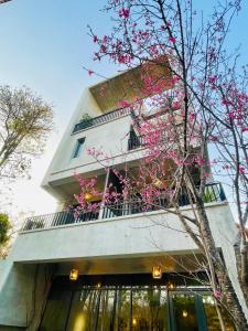 een gebouw met roze bloemen ervoor bij 沐目家 Xiang Jia Homestay in Beipu