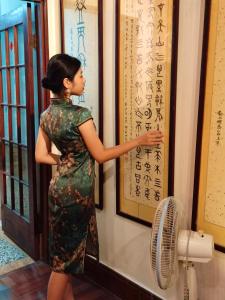 台南的住宿－福憩背包客棧- 緣憩館	，女人在看墙上的一幅画