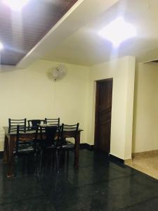 a dining room with a table and chairs and a door at High shine Homestay in Meppādi