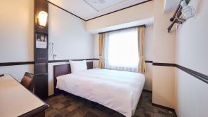 a small room with a bed and a window at Toyoko Inn Narita Airport Honkan in Narita