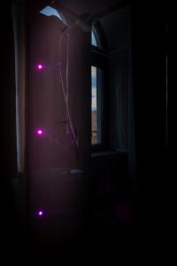 a bathroom with a shower in a dark room with pink lights at Torre Subrosa, vasca in camera cromoterapia in Viterbo