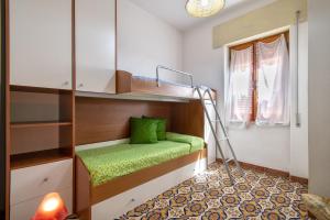 a small room with a bunk bed with a green pillow at Isola Rossa - Trilocale Grande in Isola Rossa