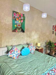 um quarto com uma cama verde com almofadas e um quadro em Viva Mexico villa em Dalung