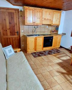 a kitchen with wooden cabinets and a sink at Il Belvedere in Nevegal