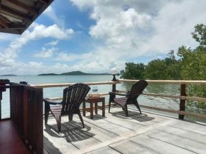 two chairs and a table on a deck overlooking the water at Navareeya House Seaview in Ko Lanta