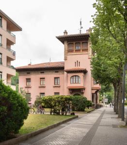 a large pink building on a city street at Apartamento con garaje en el centro de Zumaia in Zumaia