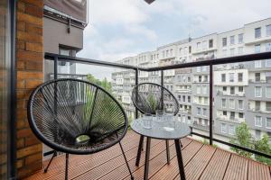 a balcony with two chairs and a table at Lux Apartment with Parking, AC & Balcony on Kepa Mieszczanska by Renters Prestige in Wrocław