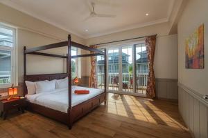 1 dormitorio con cama con dosel y ventana grande en Stayscape Spanish County 12 4BHK Virar, en Khanivde