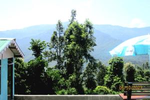 a view of a mountain range with an umbrella at Dhim Farmstay in Namchi