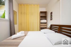 1 dormitorio con 1 cama con 2 toallas en Gecko Zen - 3* - 95m2 - 20min du cirque de Salazie - Bras-Panon, en Bras-Panon