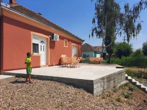 a young child standing in front of a house at Mila in Bela Crkva