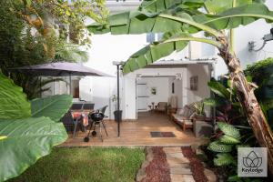 una sala de estar con un patio con un árbol en Gecko Zen - 3* - 95m2 - 20min du cirque de Salazie - Bras-Panon, en Bras-Panon