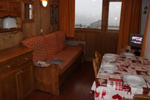uma sala de jantar com uma mesa, um sofá e uma mesa em Vanoise Appartements VTI em Val Thorens