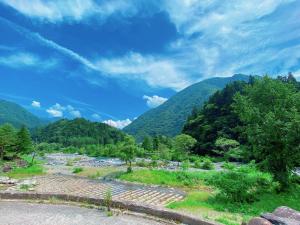 une rivière dans une vallée avec des montagnes en arrière-plan dans l'établissement Hakuunsou, à Takayama