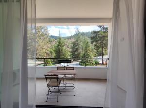 卡科佩特里亞的住宿－Rifugio Retreat Bed&Breakfast，带阳台的带桌椅的房间