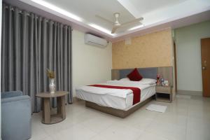 a bedroom with a bed and a table and a chair at Wood Burn Hotel in Bogra